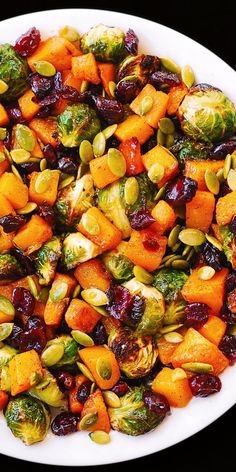 a white bowl filled with brussel sprouts and sweet potatoes