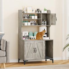 an orange cat sitting on top of a cabinet next to a couch in a living room