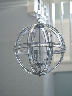 a chandelier hanging from the ceiling in a room with stairs and railings