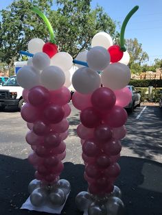 two balloons with cherries on them are standing in the street