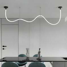 a dining room table with chairs and lights hanging from the ceiling