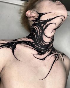 the back of a man's neck is covered in black ink