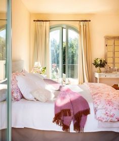 a bedroom with a bed, dresser and large glass door leading to the outside patio