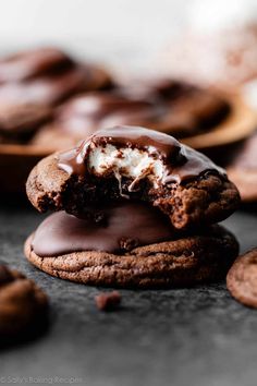 two chocolate cookies with marshmallows on top and one cookie in the middle