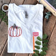 I Embroidered This Little Pumpkin To Be Worn Comfortably In The Fall! :) It’s A Super Cute And A Simple Design. I Love Anything Pumpkin Themed. Message Me For Any Questions. Thank You! Cotton V-neck T-shirt With Floral Embroidery, Fall Cotton T-shirt With Floral Embroidery, V-neck Cotton T-shirt With Floral Embroidery, Floral Embroidered Cotton V-neck T-shirt, Embroidered White T-shirt For Fall, Custom Embroidered White T-shirt For Fall, White T-shirt With Custom Embroidery For Fall, White Custom Embroidered T-shirt For Fall, Embroidered Pumpkin