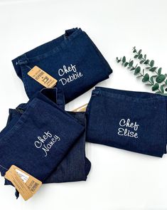 three personalized denim pouches with names on them