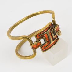 Lovely modernist bronze and enamel clamper bracelet by French designer St Luc. Gilded bronze two bands designed with geometric gilded bronze metal carved elements topped with orange and black enamel. Hook closing clasp on one side of the central medallion. Signed underside: "St Luc" with the model number.  Measurements: Inside across is 2.50 in wide (6.3 cm) x 1.94 in deep (4.9 cm) - Width is 1.19 in wide (3 cm) - Opening is 1.19 in wide (3 cm) - inner circumference is 7.32 in long (18.5 cm). It French Designer, Bronze Metal, Best Wear, French Design, Black Enamel, Jewelry Collection, Carving, Band, Bracelet