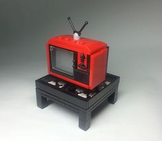 a red and black toy microwave sitting on top of a table