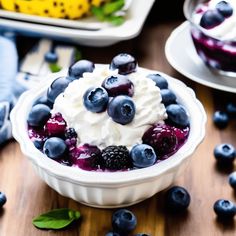 blueberry cheesecake in a white bowl with whipped cream and fresh berries on the side