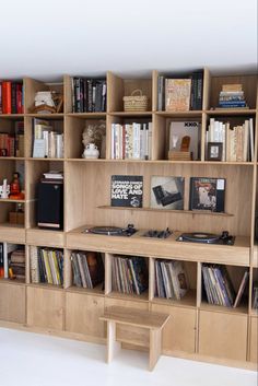 a bookshelf filled with lots of books next to a wall mounted record player