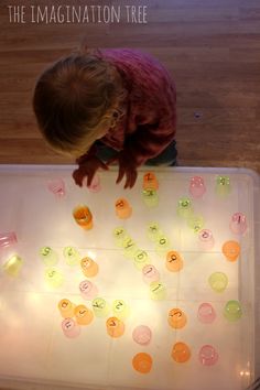 a toddler playing with an illuminated board game