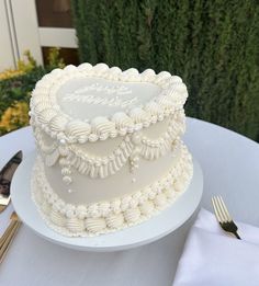 a heart shaped cake sitting on top of a table next to a knife and fork