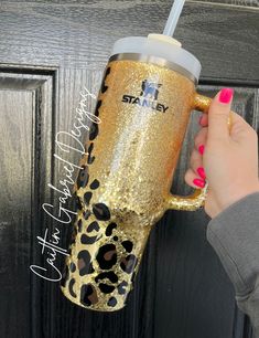 a woman is holding a leopard print coffee cup in front of a door with her name on it