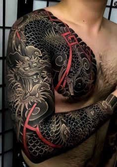 a man with a dragon tattoo on his arm and chest is posing for the camera