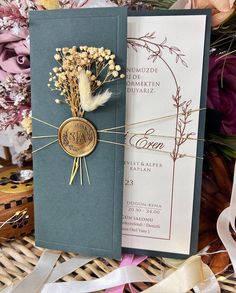 two wedding cards with flowers on them and ribbons tied to the front, sitting next to each other