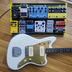 an electric guitar sitting on top of a wooden floor next to other musical instruments and amps