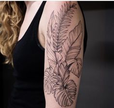 a black and white photo of a woman's arm with a fern tattoo on it