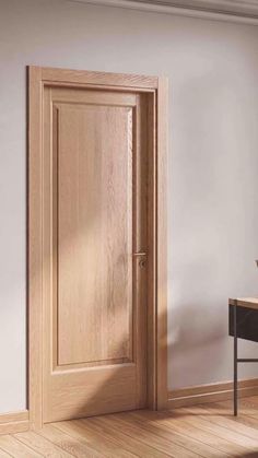 an empty room with a wooden door and chair next to the desk in front of it