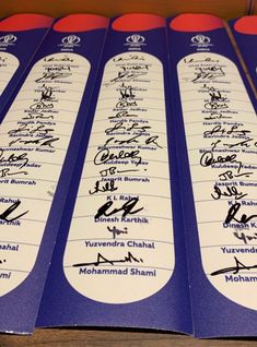 five blue and white bookmarks with autographs on them, all lined up in rows