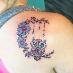 a woman's stomach with an owl and flowers tattoo on it, which is hanging from the side