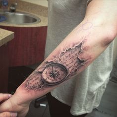 a person with a tattoo on their arm holding a clock