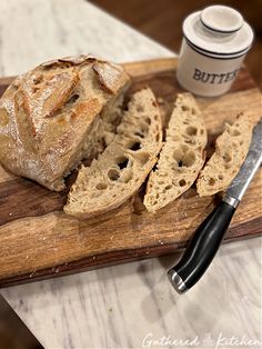 a loaf of bread sitting on top of a wooden cutting board next to a knife