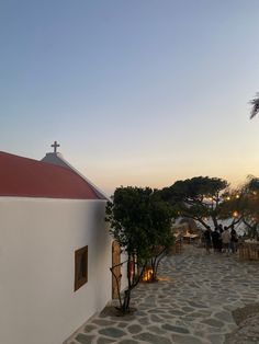 people are walking up and down the steps to a small church with a red roof