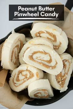 a pan filled with cinnamon rolls on top of a wooden table next to a sign that says peanut butter pinwheel candy