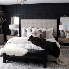 a bedroom with black walls, white bedding and fur rugs on the floor