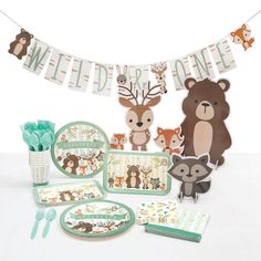 a baby shower set with woodland animals on it's clothes line and banners above the table