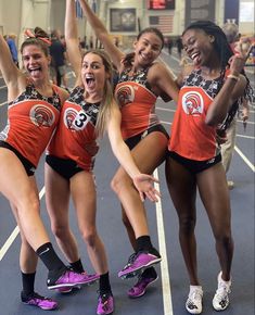 four girls in orange shirts and black shorts on roller skates posing for the camera