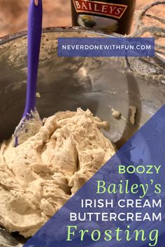 boozy bailey's irish cream frosting in a bowl with a blue spoon