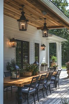 a wooden table sitting on top of a wooden floor next to a white house with lots of windows