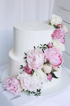 a white wedding cake with pink and white flowers