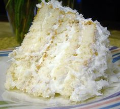 a piece of cake sitting on top of a plate next to a vase filled with flowers