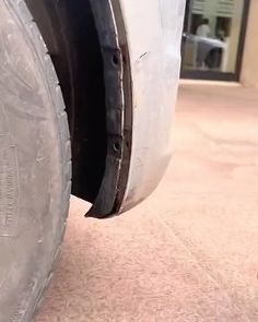 the front tire of a white truck parked in front of a building