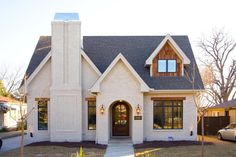 a white brick house with a black roof