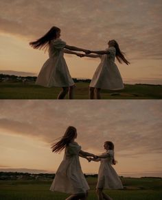 two girls in white dresses holding hands while standing on the grass at sunset with their arms around each other