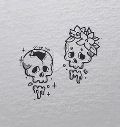 two skulls with bows on their heads and one skull has a flower in its hair