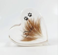 a dog paw and heart shaped glass dish with the word dad written on it's side