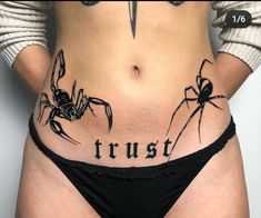 a woman's stomach with the words trust written on it and two spider tattoos