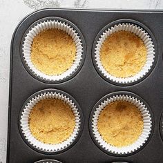 four cupcakes in a muffin tin on top of a white countertop