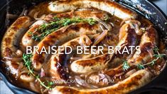 baked beer brats in a cast iron skillet with onions, mushrooms and herbs