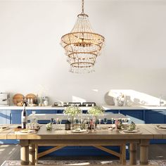 a kitchen with blue cabinets and a chandelier hanging from the ceiling