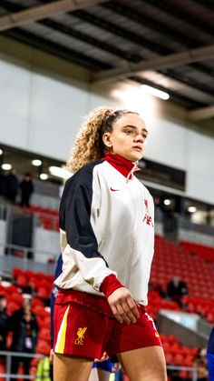 a woman in red shorts standing on a soccer field