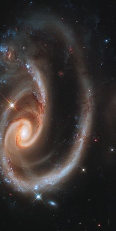 two spirally shaped objects in the middle of a space filled with stars and dust