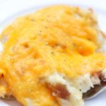 a close up of a piece of food on a plate with broccoli and cheese