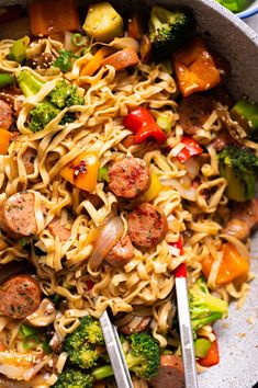 a bowl filled with noodles, sausage and broccoli