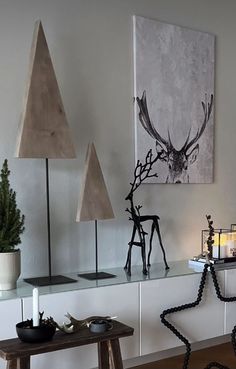 a living room filled with furniture and decor on top of a wooden floor next to a painting