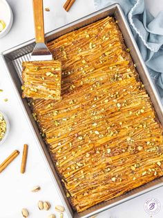 a baking pan filled with baked crackers and nuts next to a bowl of peanuts